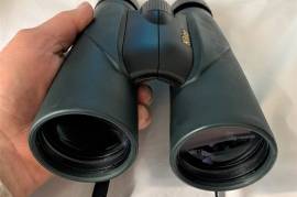 Nikon Sporter EX 10x50 binocular Roof  Water proof, Powerful binoculars with 10x magnification and 50mm diameter front lens. This binocular combines very good optical quality and robustness and is therefore ideal for activities such as trekking and nature observation. The compact and lightweight housing is nitrogen-filled and therefore fog-free. A rubber coating ensures easy handling. Multi-layer coated lenses ensure a bright and brilliant image, the design with large exit pupil distance ensures a sharp field of view and comfortable viewing through binoculars for spectacle wearers. Waterproof (up to 10min at 1m depth). 98m field of view at 1,000m.